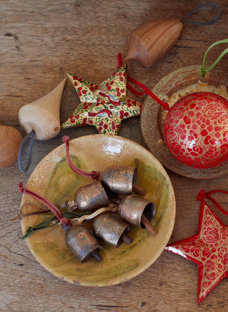 artisan christmas decorations including indian cow bells, wooden baubles and red hand-painted stars