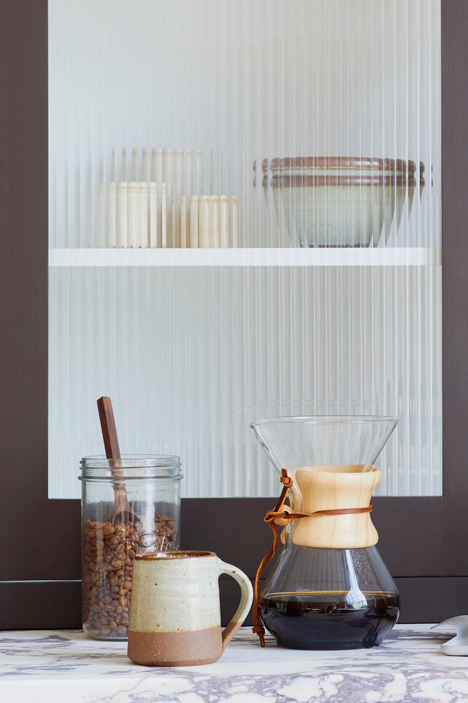 a coffee scene with chemex coffee maker, mug and le parfait screw top jar of coffee beans