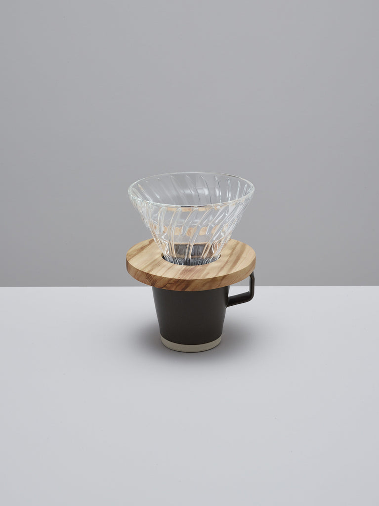 Hario olive wood V60 glass dripper in use over a coffee cup